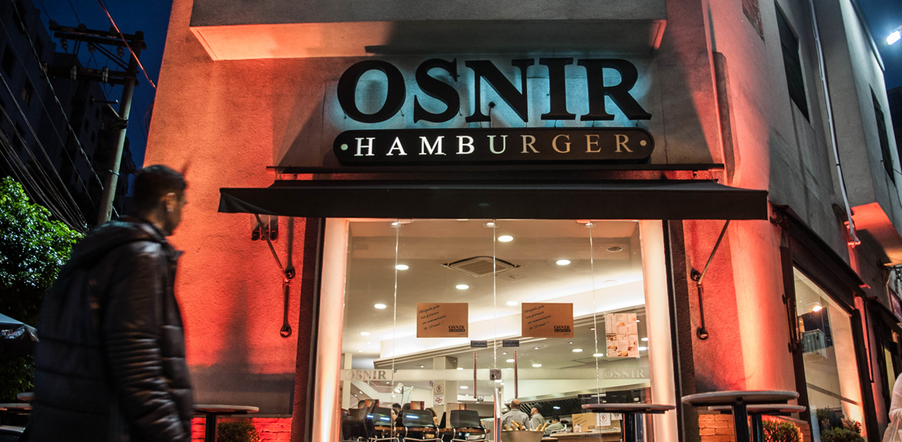Fachada iluminada da Osnir Hamburger à noite
